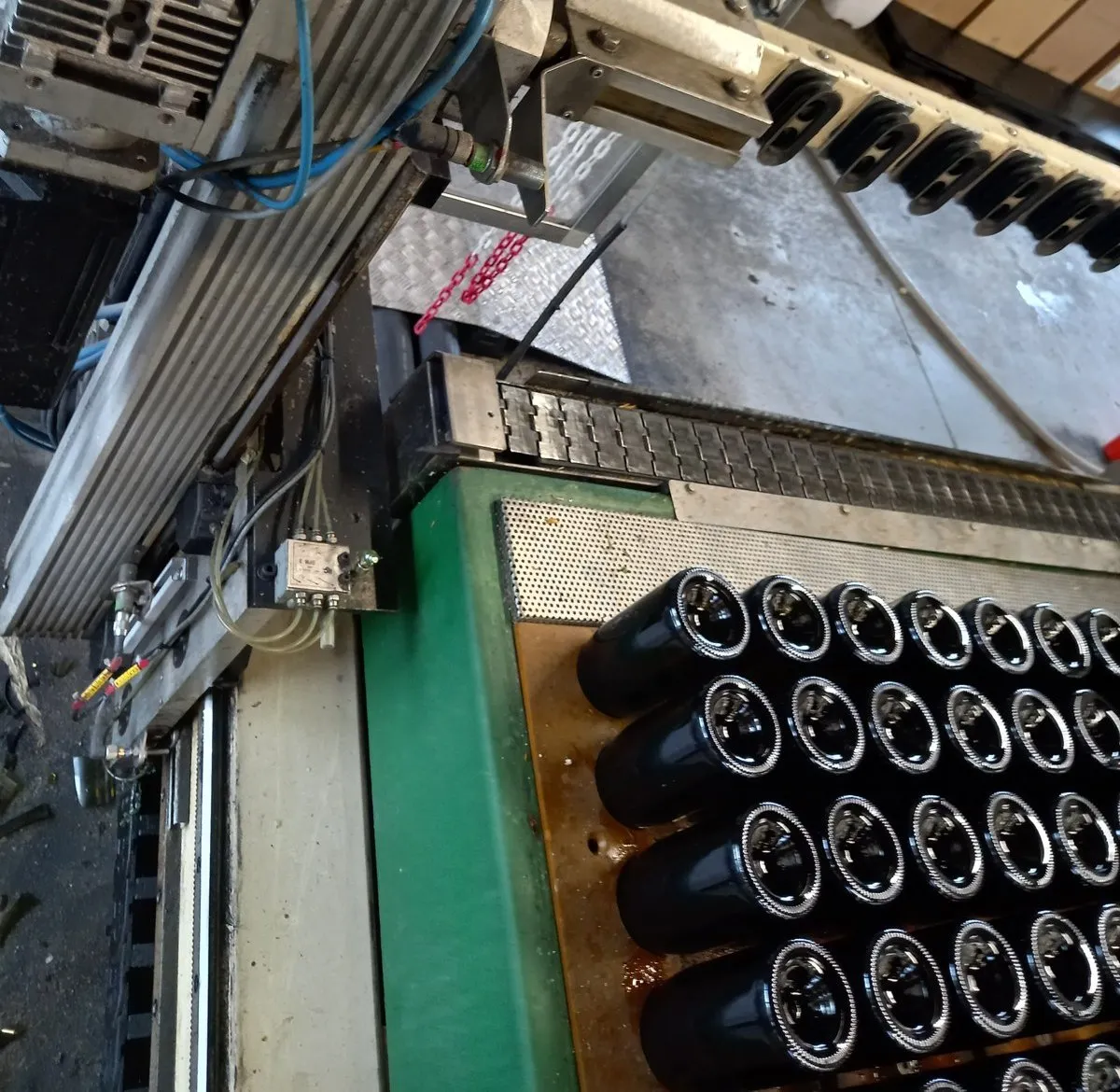 Préhenseur de la machine Champagel au-dessus d’un plateau de bouteilles